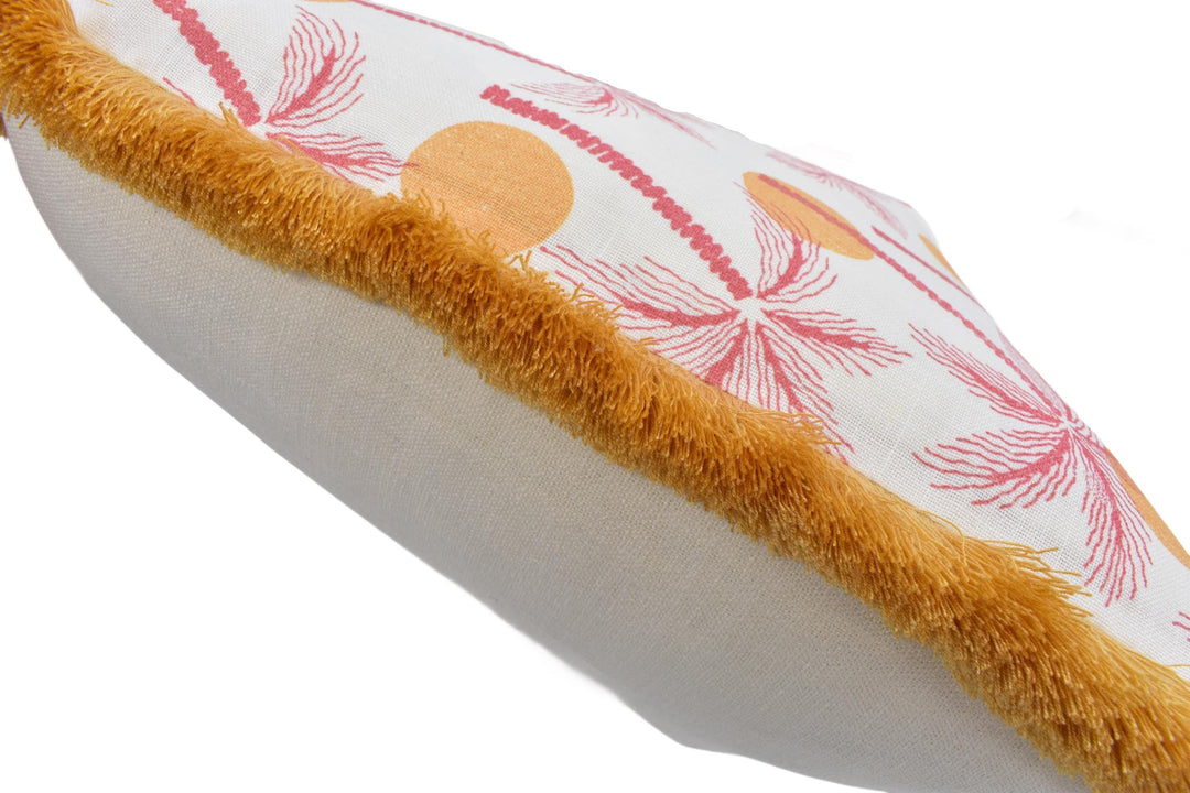 A close-up view of a decorative pillow with a floral pattern and a fuzzy trim.