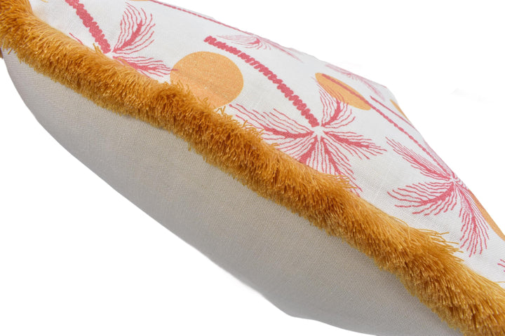 A close-up view of a decorative pillow with a floral pattern and a fuzzy trim.