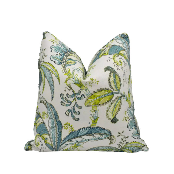 a decorative pillow with a floral pattern in shades of green and blue.