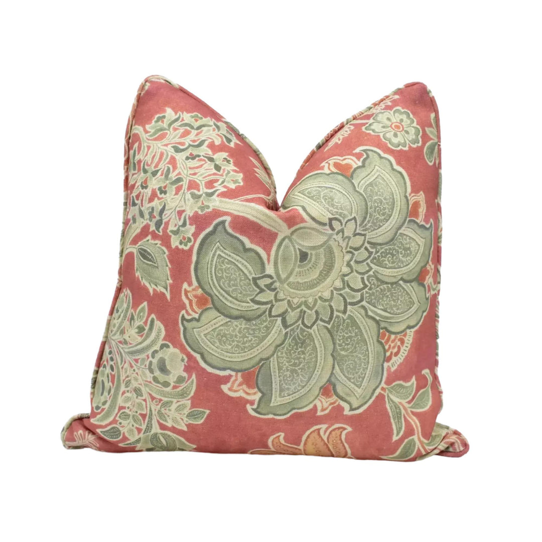 a decorative pillow with a floral pattern in shades of red and green.