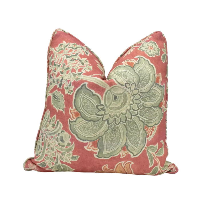 a decorative pillow with a floral pattern in shades of red and green.