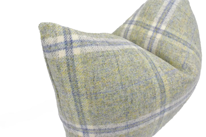 A close-up image of a plaid pillow with a light green and blue color scheme.