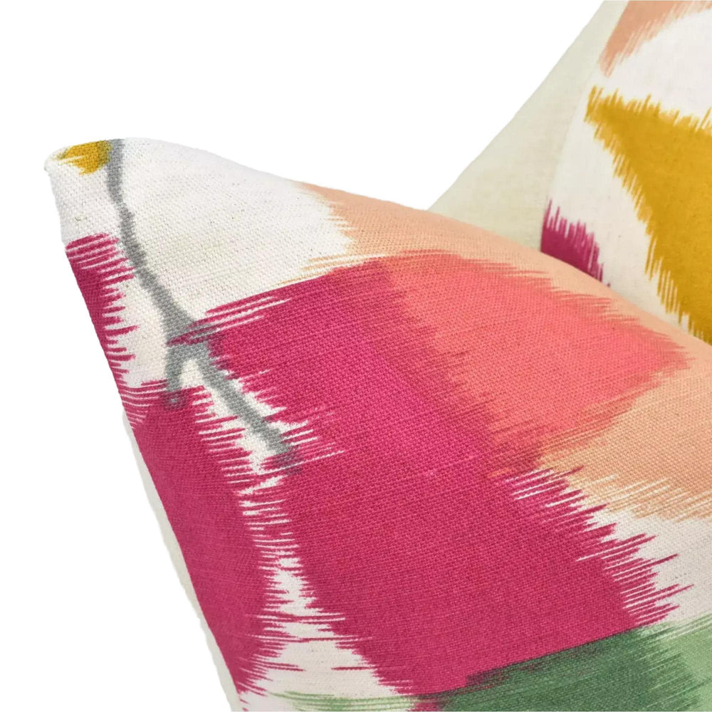 a close-up view of a vibrant, colorful pillow with a bold, abstract pattern in shades of pink, orange, and yellow.