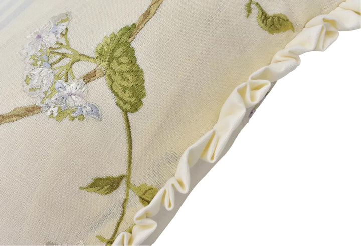a close-up view of a fabric with a floral pattern, featuring a branch with flowers and leaves. The fabric appears to be a light-colored material, possibly a white or cream-colored fabric. The image does not contain any text or other objects, and the focus is on the intricate details of the floral design.