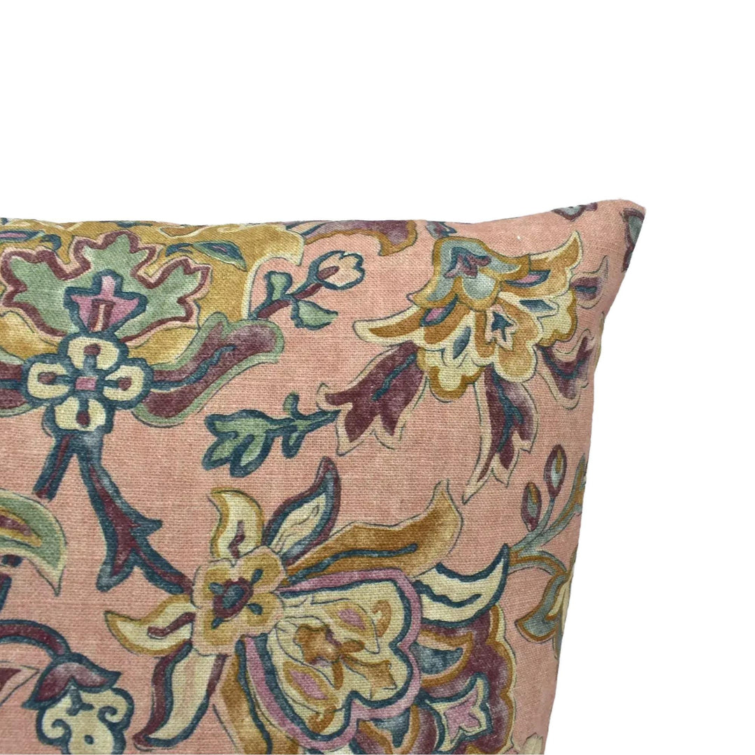 A decorative pillow with a floral pattern in shades of pink and green.