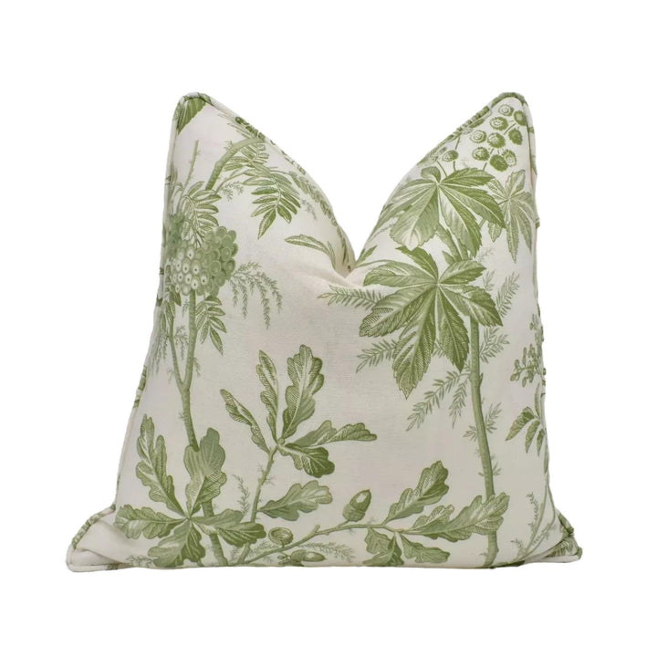 A decorative pillow with a green leaf pattern on a white background.