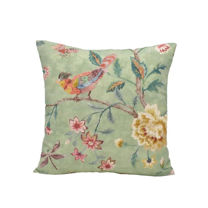 A square throw pillow with a vibrant floral and bird design in shades of green, pink, yellow, and red.