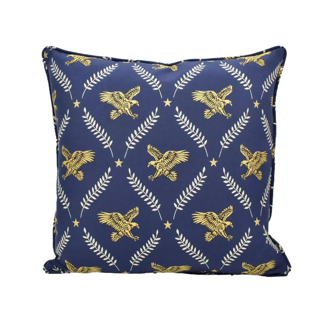 A navy blue throw pillow with a repeating pattern of gold eagle and leaf designs.