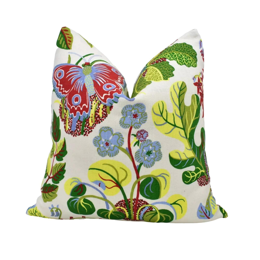 a vibrant, colorful pillow with a butterfly design and various floral and leaf patterns.