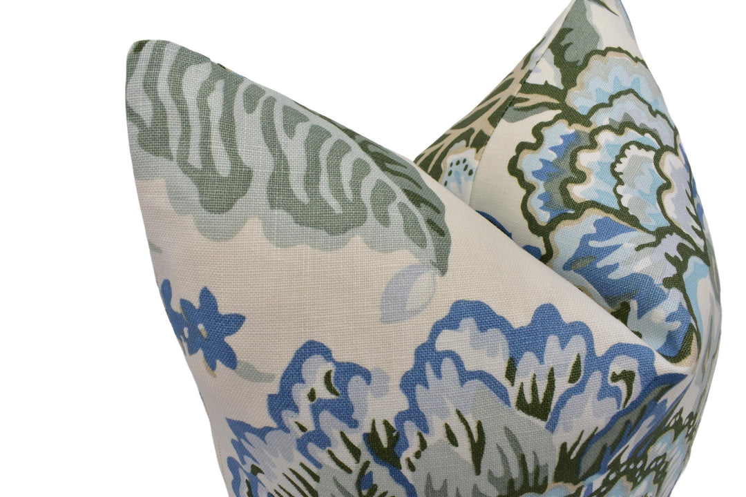 a close-up view of a decorative pillow with a floral pattern in shades of blue and green.