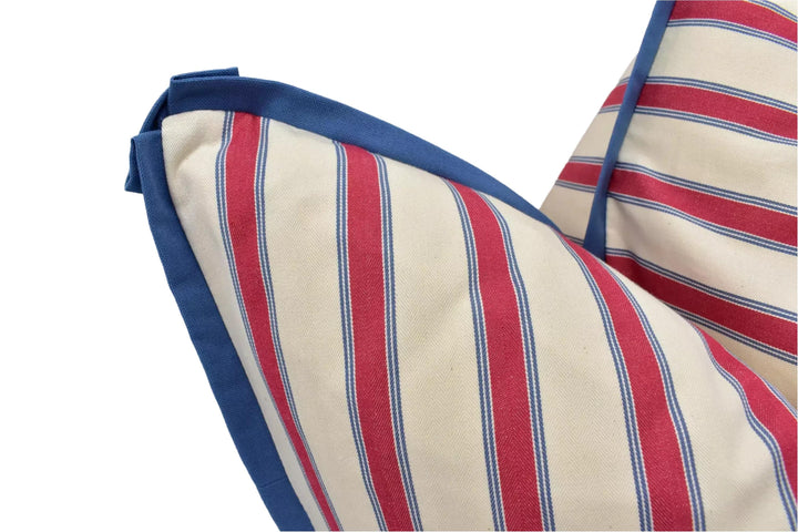 A close-up view of a striped fabric with red and blue stripes, featuring a blue trim along the edges.