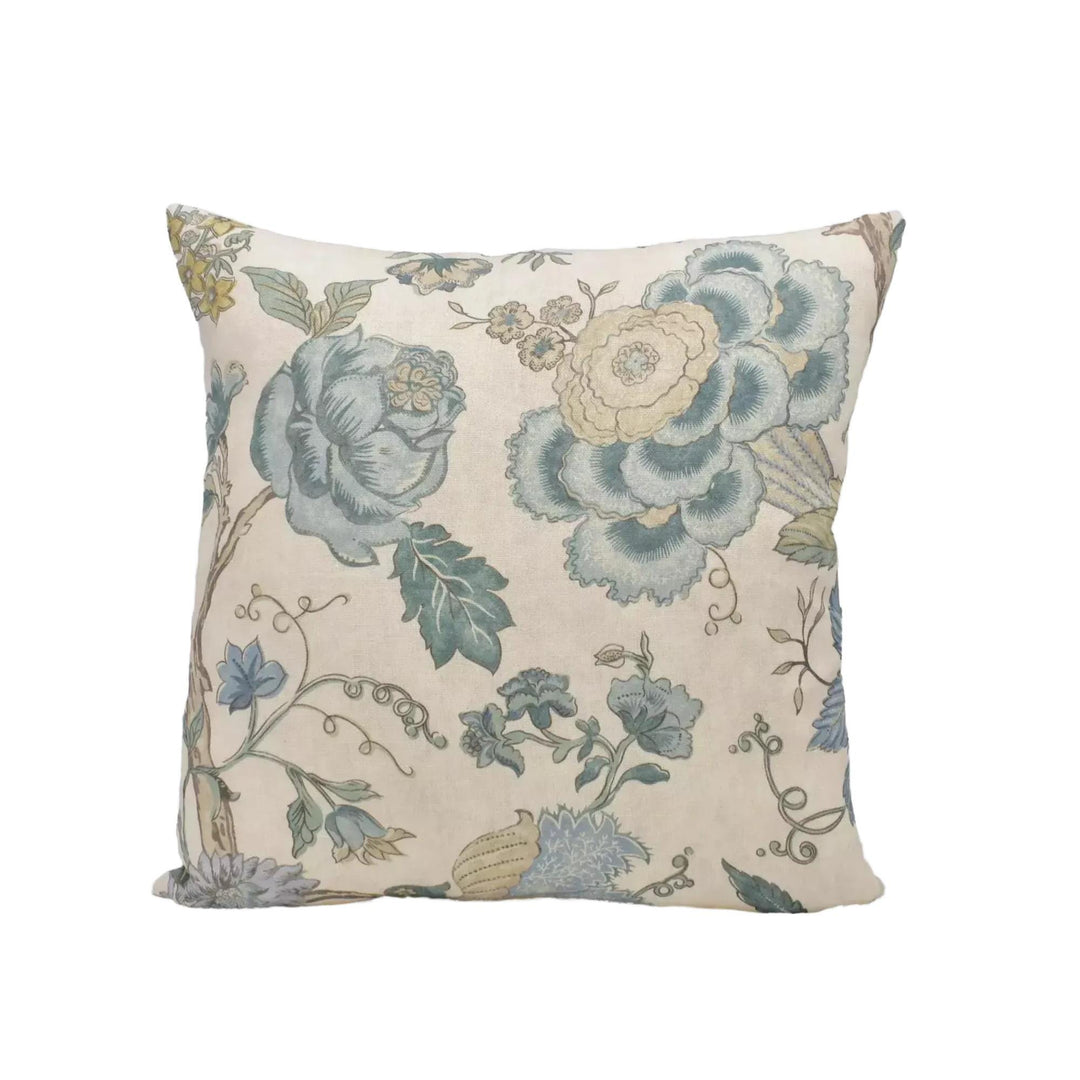 A square throw pillow with a floral print design in shades of blue, green, and white.
