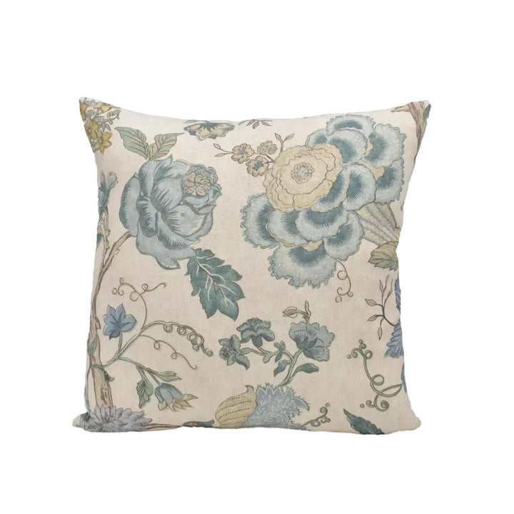 A square throw pillow with a floral print design in shades of blue, green, and white.