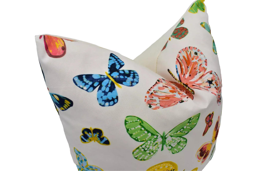 a white pillow with a vibrant and colorful butterfly pattern.
