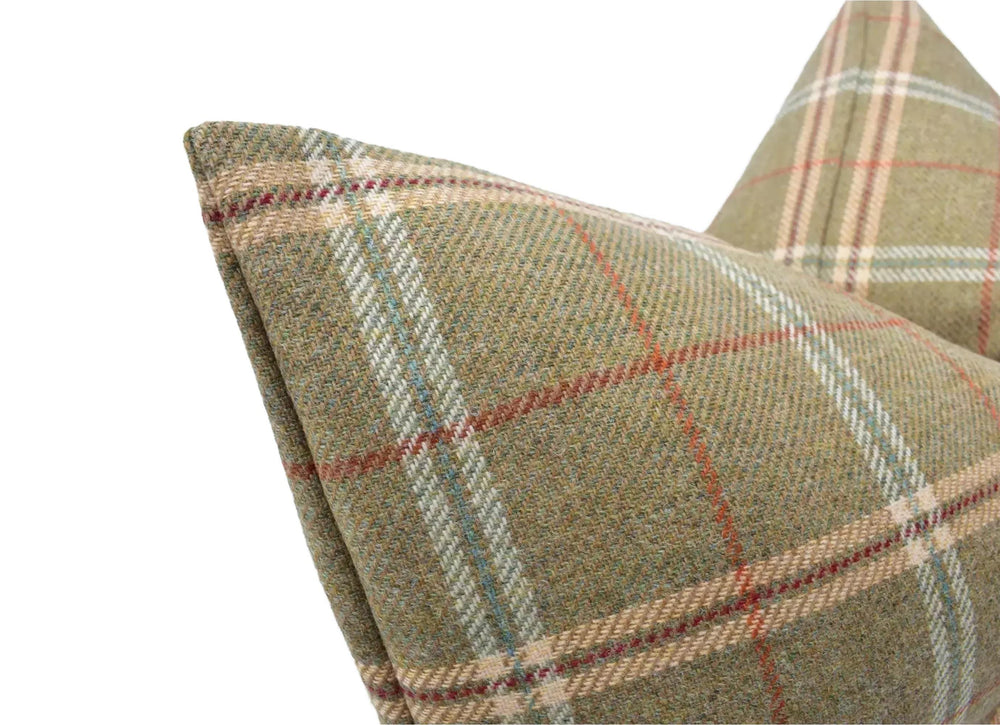 A close-up image of a plaid fabric with a geometric pattern of red, green, and beige stripes.