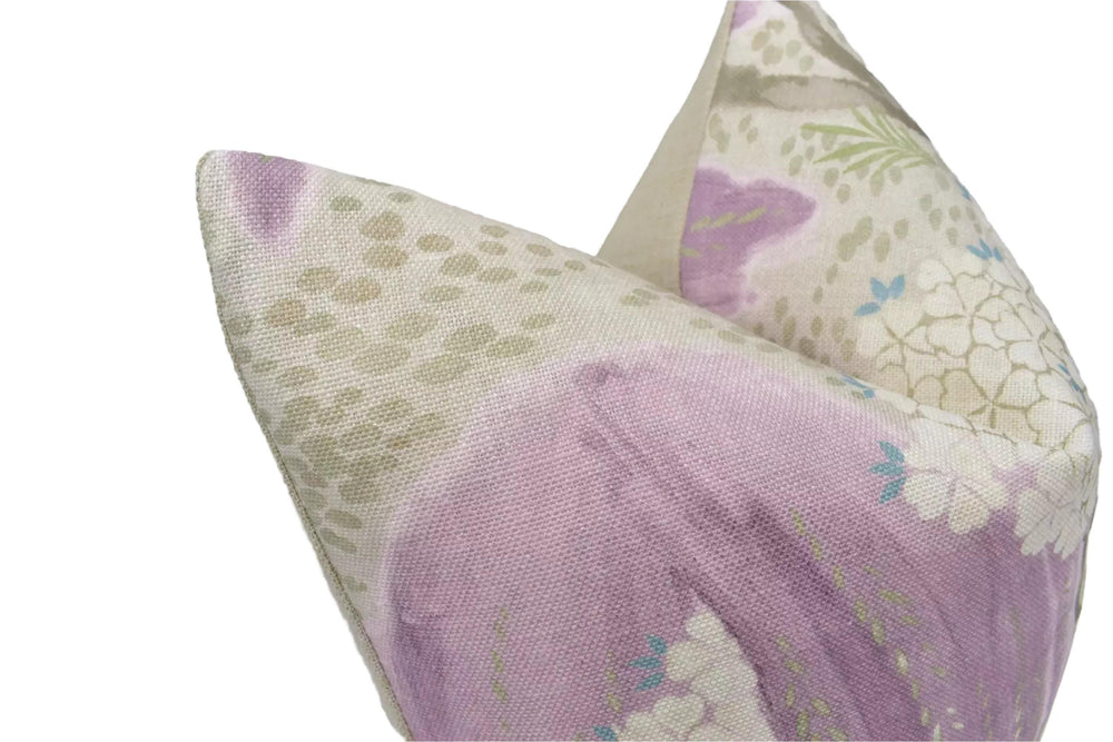 a close-up view of a decorative pillow with a floral pattern in shades of purple and green.