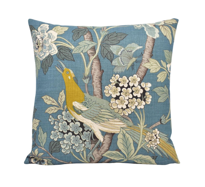 a blue pillow with a bird and flowers on it
