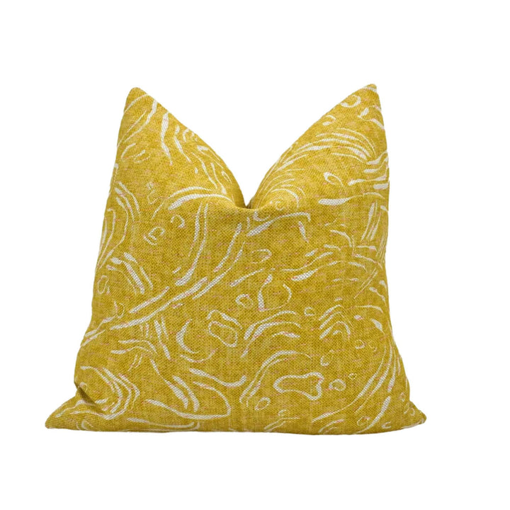 A yellow throw pillow with a white floral pattern.