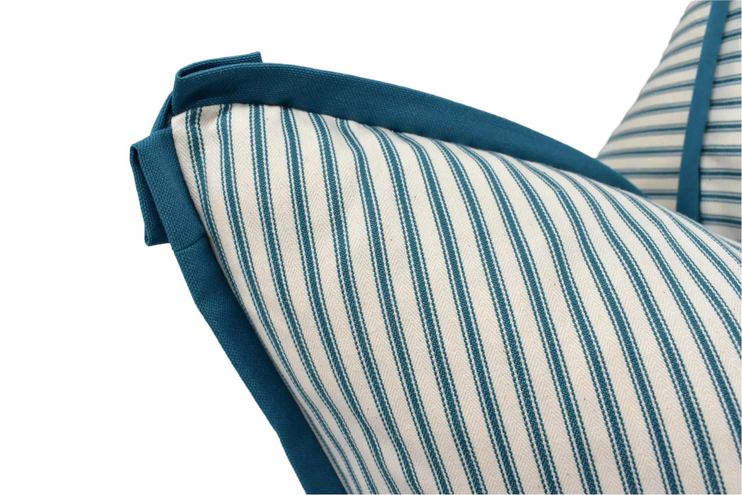 A close-up view of a striped pillow with a blue trim, showcasing the pattern and texture of the fabric.