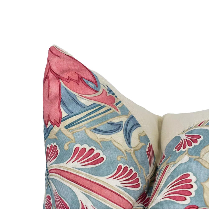 a close-up view of a decorative pillow with a vibrant floral pattern in shades of blue, pink, and white.