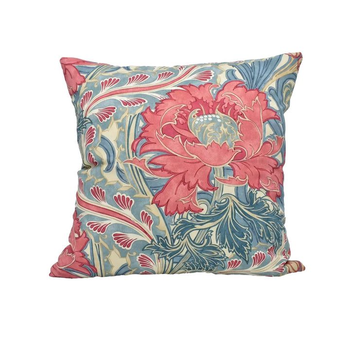 A decorative throw pillow with a floral pattern in shades of pink, blue, and green.