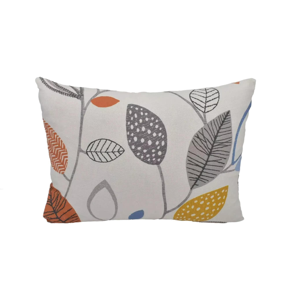 A white pillow with a pattern of colorful leaves and branches.