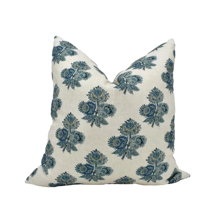 A white pillow with a repeating pattern of blue and green floral designs.