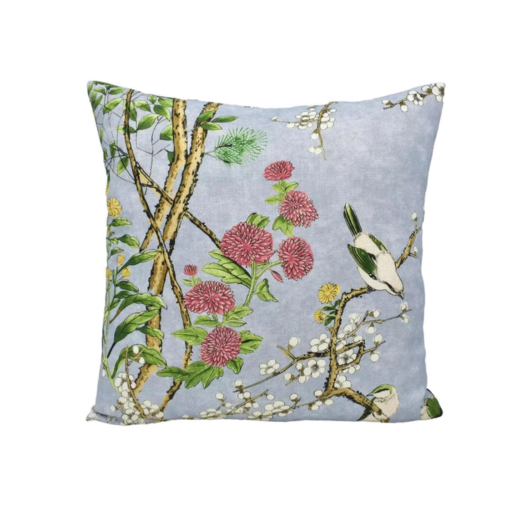 A decorative throw pillow with a floral and bird motif.