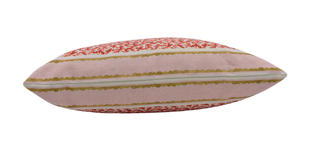 A pink and red striped pillow with a floral pattern.