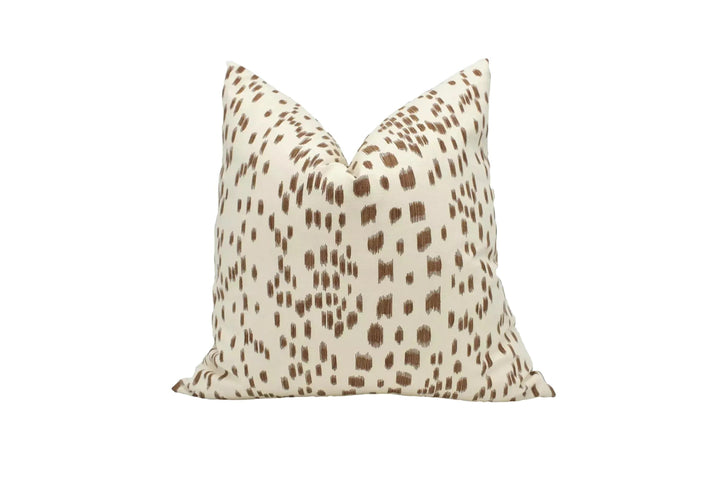 A single throw pillow with a spotted pattern in shades of brown and beige.