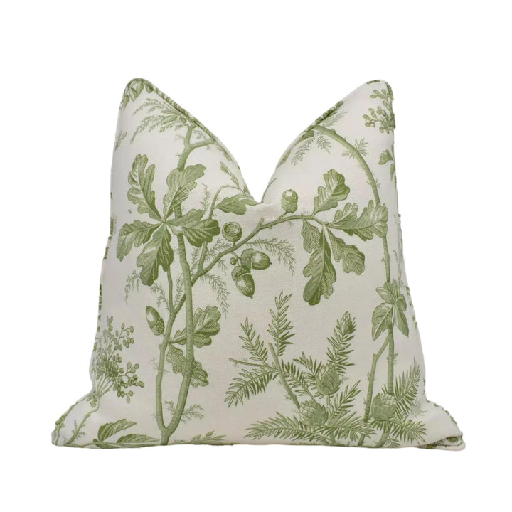 A white pillow with a green leaf and branch pattern.