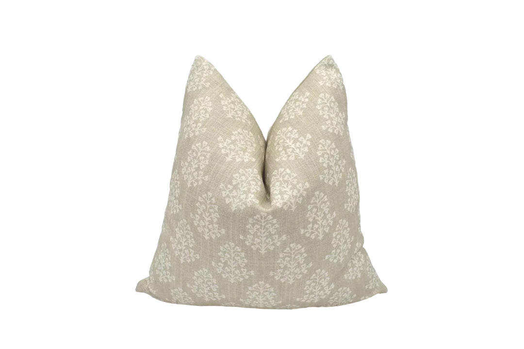 A beige throw pillow with a floral pattern is placed against a white background.