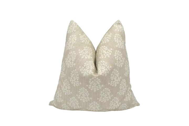 A beige throw pillow with a floral pattern is placed against a white background.