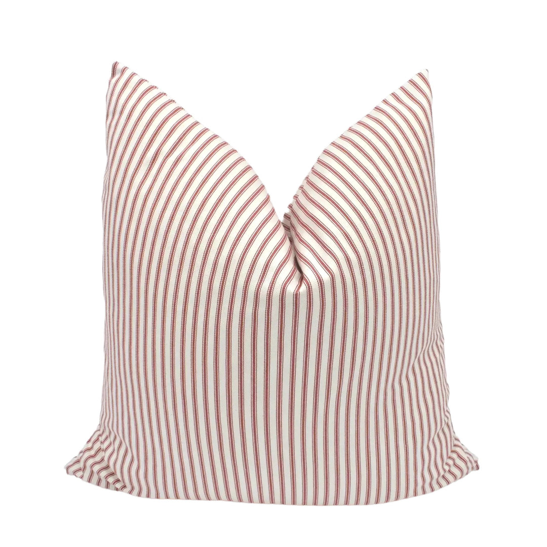 A red and white striped pillow is placed against a white background.