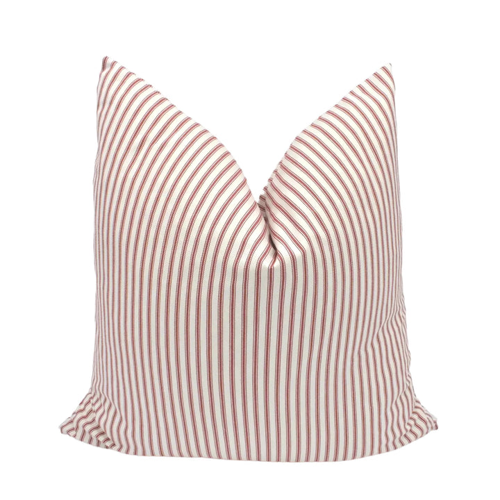 A red and white striped pillow is placed against a white background.