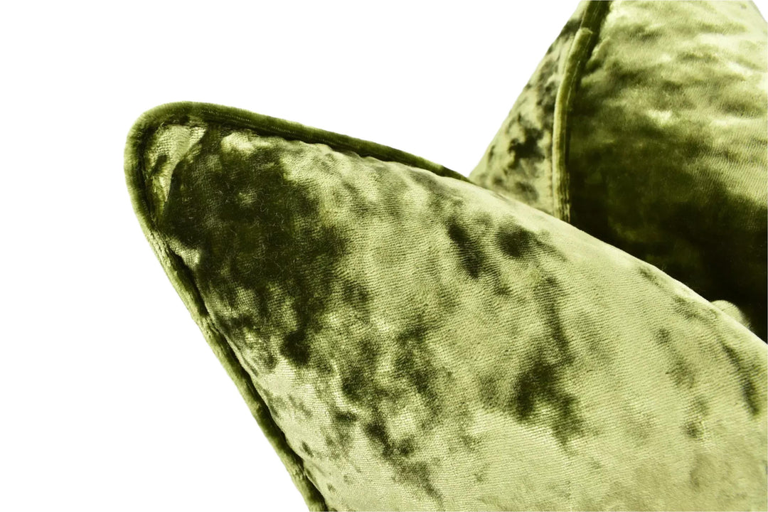 A close-up view of a green velvet cushion with a textured, plush appearance.