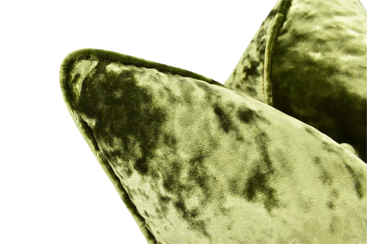 A close-up view of a green velvet cushion with a textured, plush appearance.