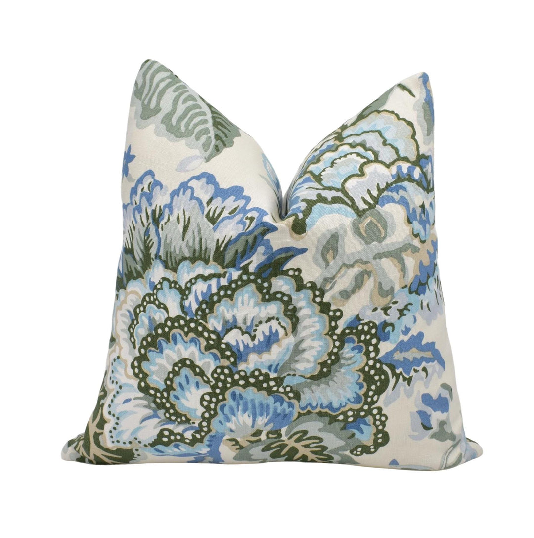 a decorative pillow with a floral pattern in shades of blue and green.