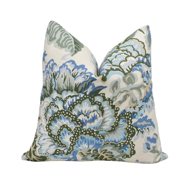 a decorative pillow with a floral pattern in shades of blue and green.