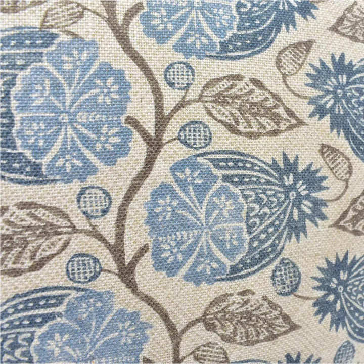 a close-up view of a fabric with a floral pattern in shades of blue and brown. The pattern includes various flower-like shapes and leaves, creating a visually appealing and intricate design.