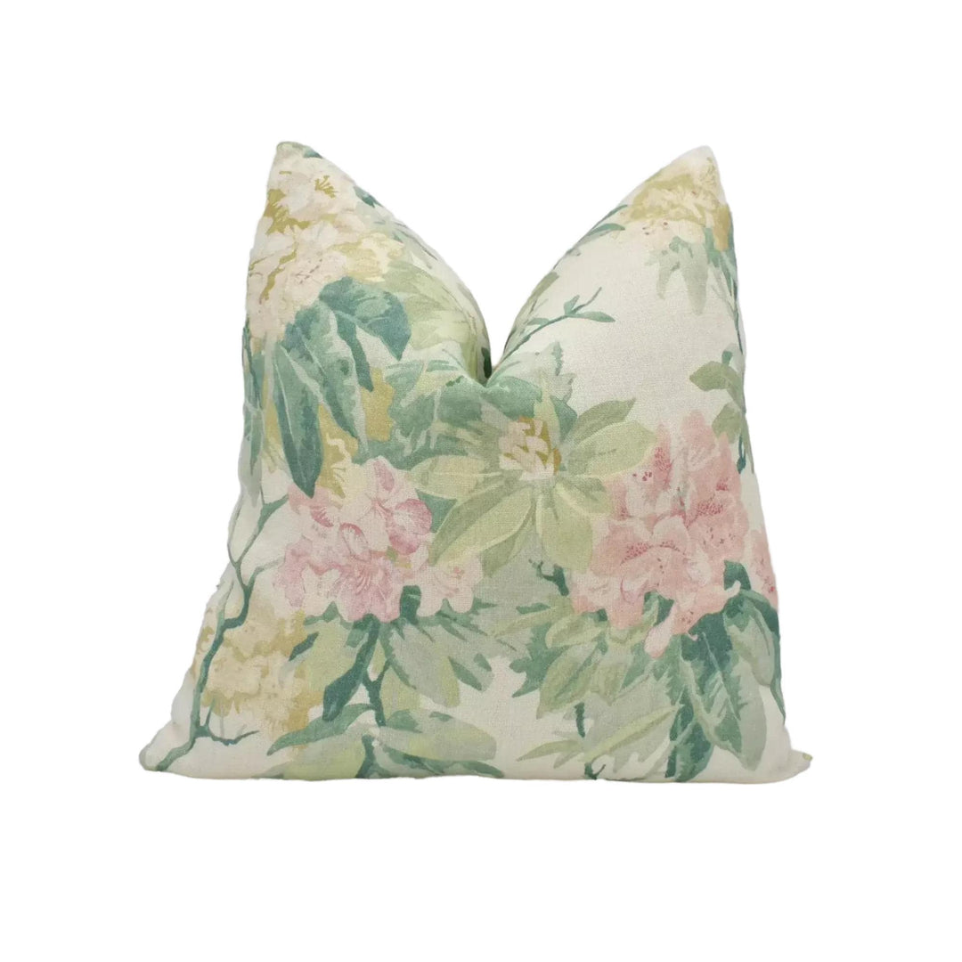 A white pillow with a floral print design featuring pink and green flowers.