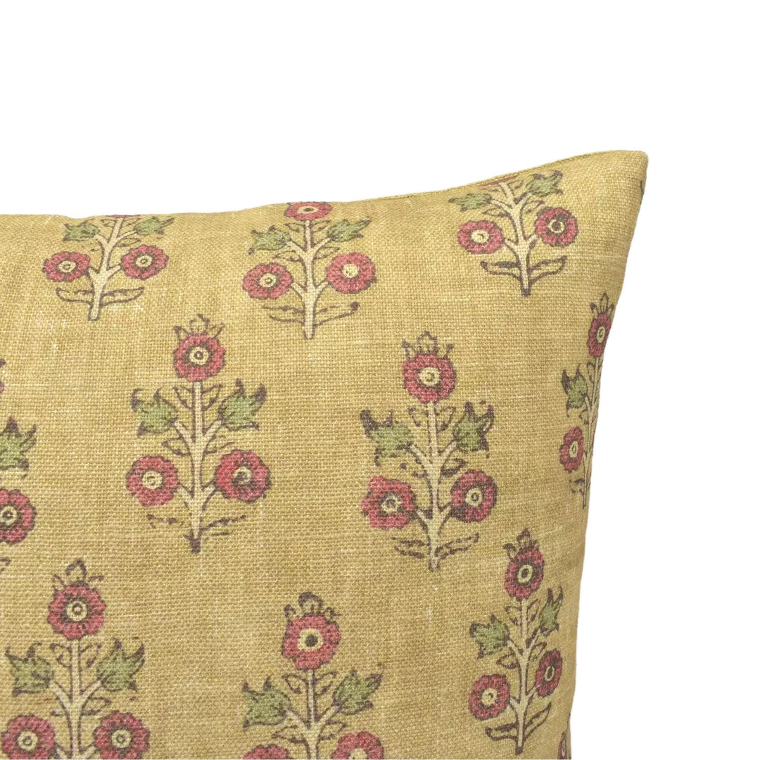 a close-up view of a decorative pillow with a floral pattern on a beige background.