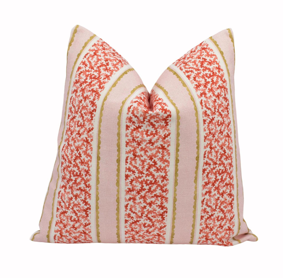 A decorative pillow with a floral pattern in shades of pink and red, featuring vertical stripes.