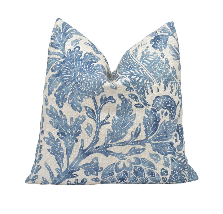 a blue and white pillow on a white background