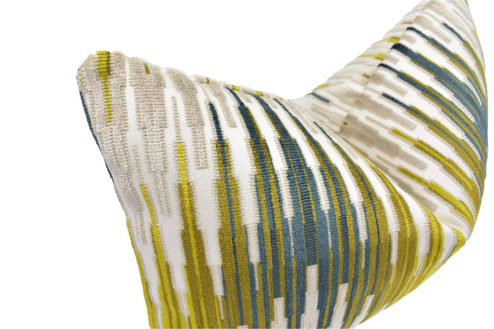 A close-up view of a decorative pillow with a striped pattern in shades of yellow, white, and blue.