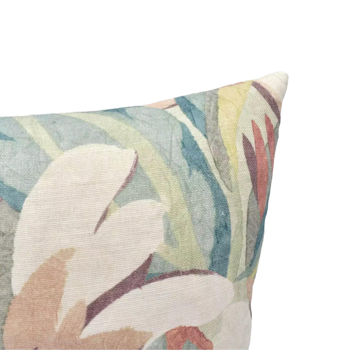 A close-up view of a colorful, patterned pillow against a plain background.