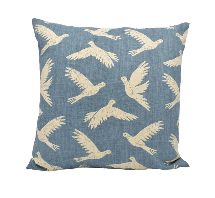 a blue pillow with white birds on it