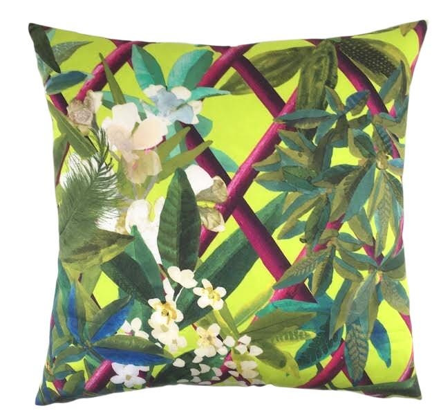 a green pillow with flowers and leaves on it