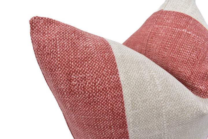 A close-up view of a red and white striped pillow against a white background.