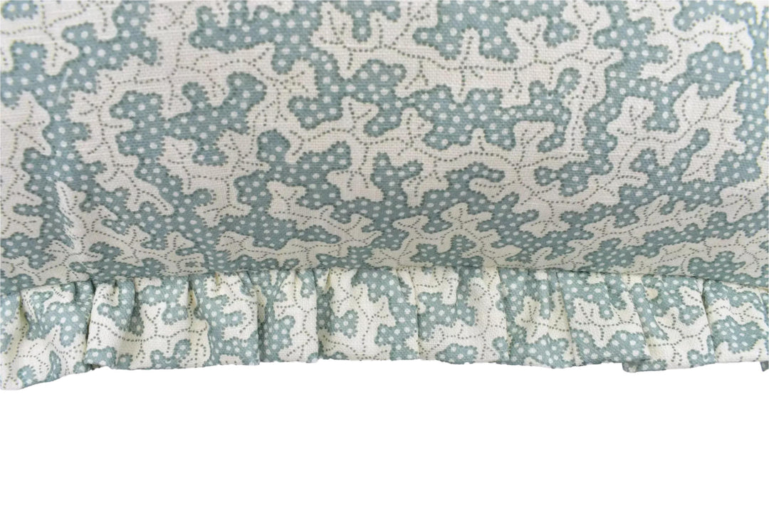 a close-up view of a fabric with a floral pattern, featuring a ruffled trim.